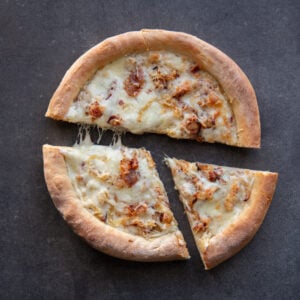 11. Pizza Flammekueche (sauce crème au vin blanc, lardons et oignons grillés) - 9” 1-2 portions